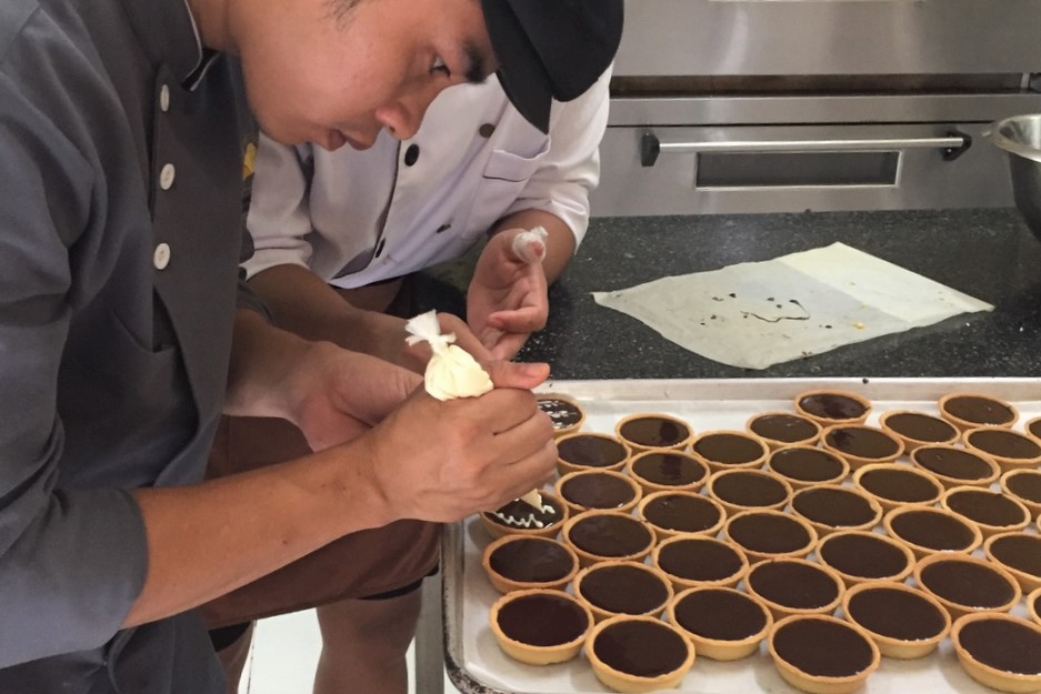 Decorating chocolate tarts at La Boulangerie Française, Huế, Vietnam